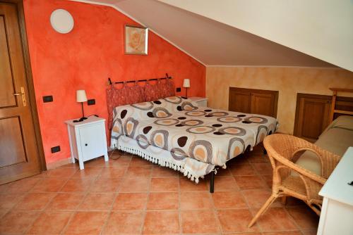 Un dormitorio con una cama en una habitación con paredes naranjas. en Alla Quercia, en Monterotondo