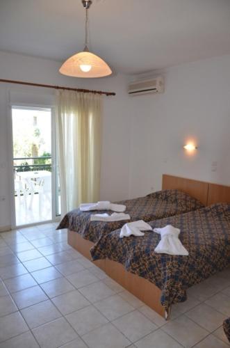a hotel room with two beds and a window at Villa Elia in Limenas