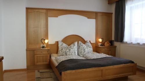 een slaapkamer met een bed met een houten hoofdeinde en kussens bij Ferienwohnung Eder in Hippach