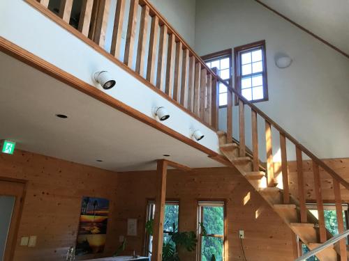 a staircase in a house with wooden walls and ceilings at Guesthouse Irago in Tahara