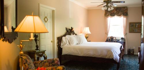 
a bedroom with a bed, chair, and lamp at The Sanford House Inn & Spa in Arlington
