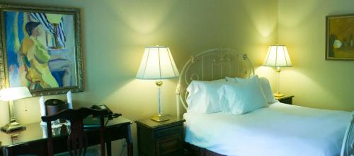 
a bedroom with a bed, lamp and a painting on the wall at The Sanford House Inn & Spa in Arlington
