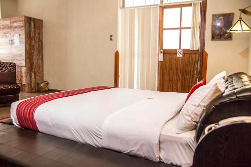 a large bed in a room with a window at Hotel Monasterio San Pedro in Cusco