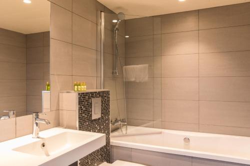 a bathroom with two sinks and a tub at Thon Partner Hotel Sortland in Sortland