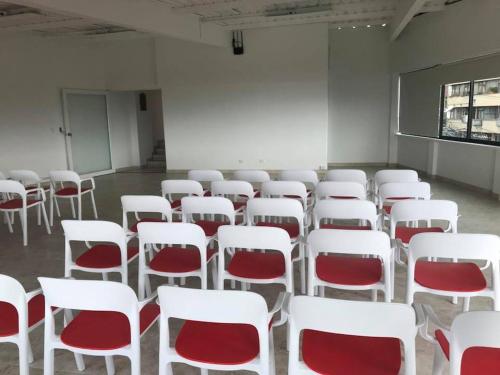 a room with white chairs and red chairs at Hotel Santa Monica in Fusagasuga