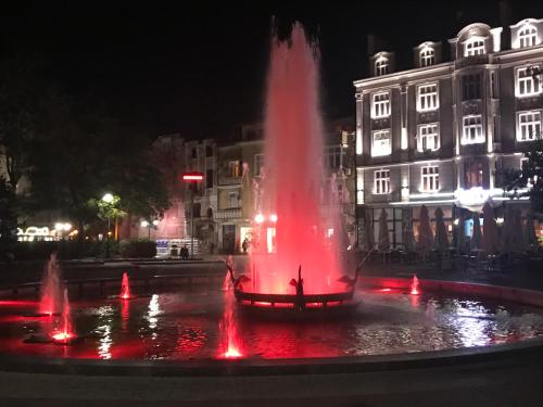 a fountain with red lights in a city at night at Къща Стария град in Plovdiv