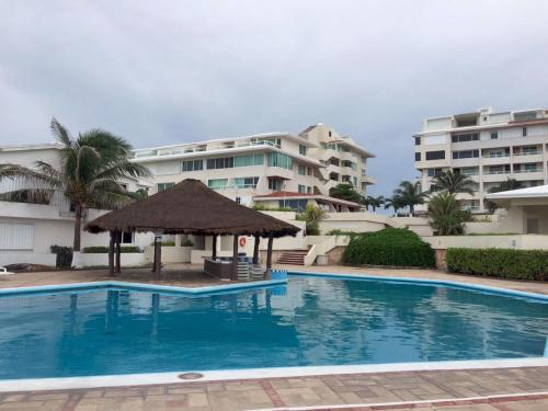 a swimming pool in front of some apartment buildings at Departamento en zona hotelera in Cancún