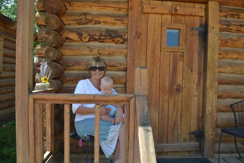 a woman holding a baby in front of a cabin at Escalante Outfitters in Escalante
