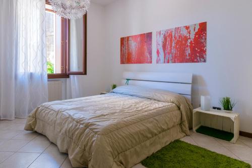 ヴィットリオ・ヴェネトにあるCasa Arialeのベッドルーム1室(ベッド1台付)が備わります。壁には絵画が飾られています。