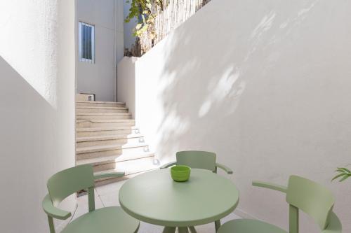 a white table and chairs in a room with stairs at Domus 21 - Entreparedes in Porto