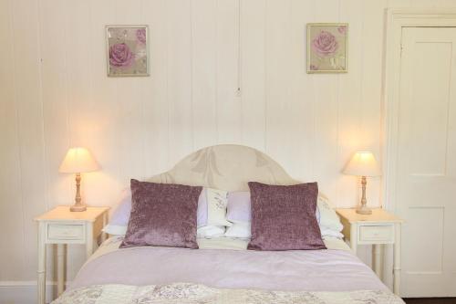 a bedroom with a bed with two tables and two lamps at Scenery Cottage in Bridford