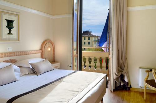 a bedroom with a bed and a balcony at Grand Hotel Vittoria in Montecatini Terme