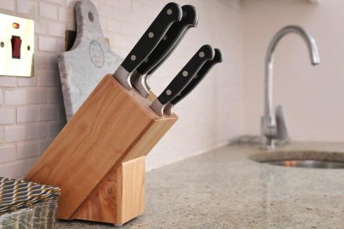 a knife block with three knives in it on a counter at Square Mile Residences in London