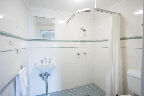 a bathroom with a shower, toilet and sink at Arena Hotel (formerly Sleep Express Motel) in Sydney