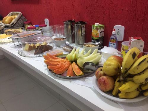 Una mesa con dos platos de fruta encima. en Trevo De Arraial pousada em cabo frio, en Cabo Frío