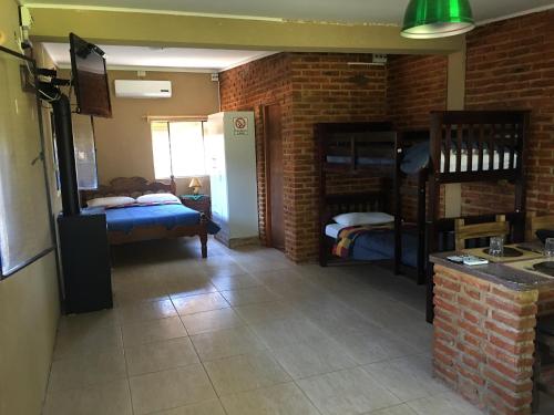 a room with two bunk beds and a kitchen at El Tajamar in Fray Bentos