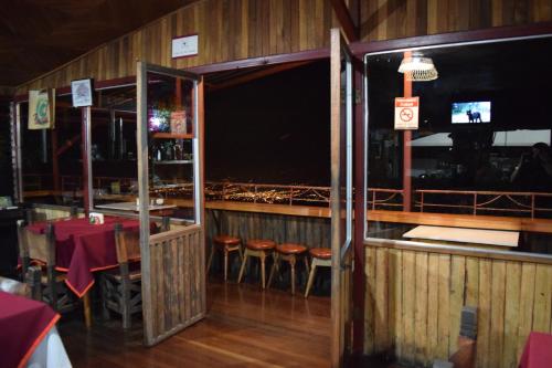 a dining room with a table and chairs and a large window at Mirador Valle del General in La Ese