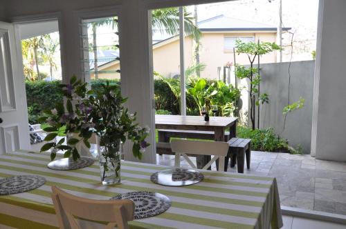 A restaurant or other place to eat at MODERN 3 BEDROOM APARTMENT IN TRADITIONAL QUEENSLANDER , PATIO, LEAFY YARD, POOL