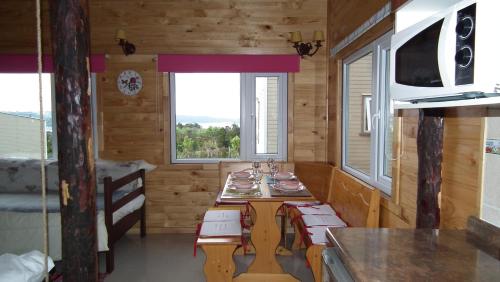 a small kitchen with a table in a log cabin at Cabañas Sol de Aucar in Quemchi