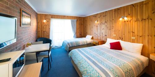 Habitación de hotel con 2 camas y TV en Kookaburra Motor Lodge en Halls Gap
