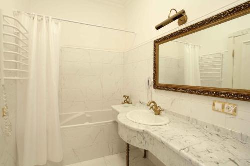 فندق أوليمبيك في كييف: حمام أبيض مع حوض ومرآة