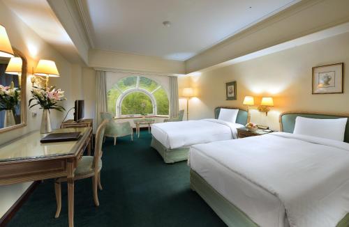 鹿谷的住宿－溪頭米堤大飯店，酒店客房配有两张床和一张书桌