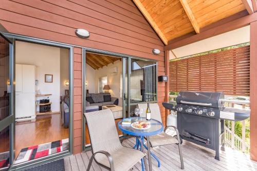a patio with a grill and a table and chairs at Abri Apartments in Paihia