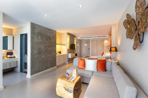 a living room with a couch and a bed at Cape Sienna Phuket Gourmet Hotel & Villas - SHA Extra Plus in Kamala Beach