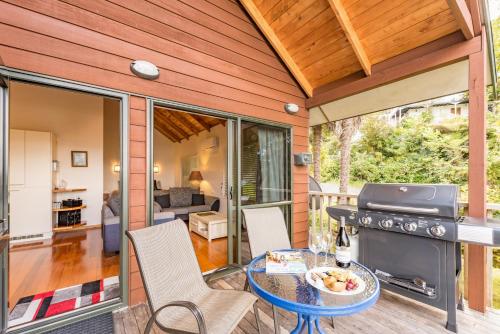 a patio with a table and chairs and a grill at Abri Apartments in Paihia
