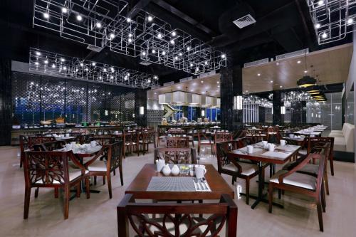 a restaurant with wooden tables and chairs and lights at Aston Pasteur in Bandung