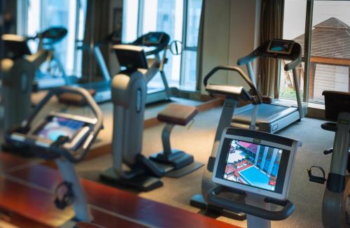 a gym with cardio machines and a cell phone at Marco Polo Jin Jiang in Jinjiang