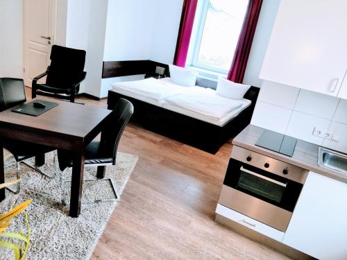 a living room with a bed and a table and a desk at Aparthotel - Stadtvilla Premium in Schweinfurt
