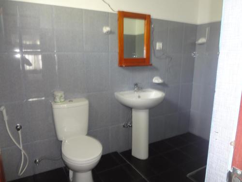 a bathroom with a toilet and a sink at Ceylon Surf Guest and Restaurant in Weligama