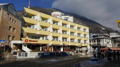 a large building on a street with a mountain at Hotel Bernerhof in Interlaken