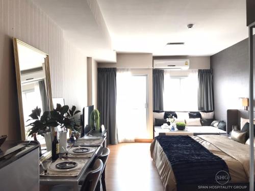 a bedroom with a bed and a table and a couch at Stay in Style, Stay On The Cloud RS504 in Chiang Mai