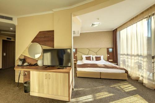 a bedroom with a bed and a flat screen tv at SPA Hotel Infinity Park Velingrad in Velingrad