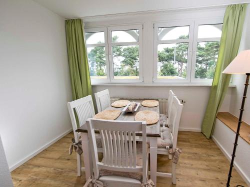comedor con mesa, sillas y ventana en Villa "Freia" in Binz - WG11 mit Meerblick und Balkon, en Binz
