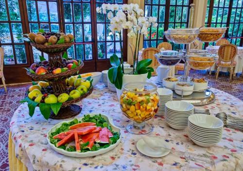 una mesa con platos de comida y cuencos de fruta en Grand Hotel Royal, en Viareggio
