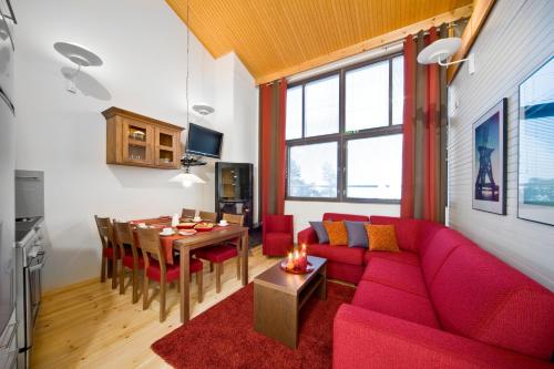 a living room with a red couch and a table at Holiday Club Pyhä HolySuites in Pyhätunturi