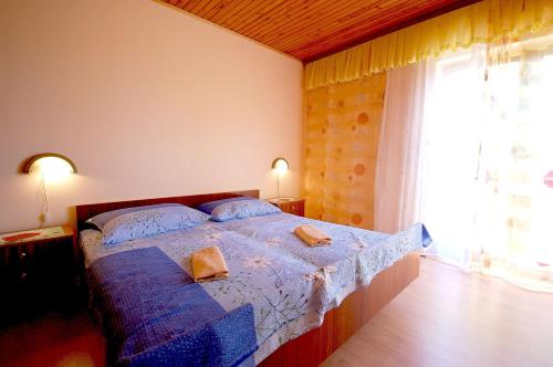 a bedroom with a bed with two pillows on it at Apartments Begic by El-Pi Tours in Malinska