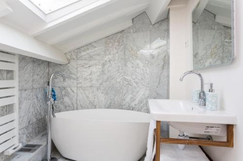 a bathroom with a white tub and a sink at Ateliers de Montmartre ADM in Paris