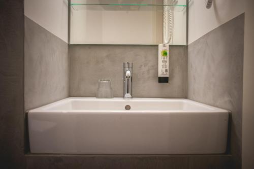 a white sink in a bathroom with a mirror at Hotel Alexander in Wiesbaden