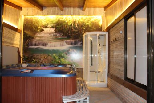 a bath tub in a room with a painting on the wall at Los Laureles Casa Rural in Urda