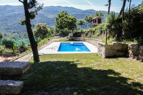 a backyard with a swimming pool and a house at Encostas da Torre in Terras de Bouro