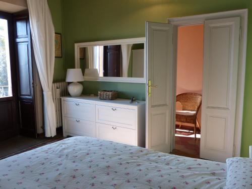 ArizzanoにあるCasa Amabile con Piscinaのベッドルーム1室(ベッド1台、ドレッサー、鏡付)
