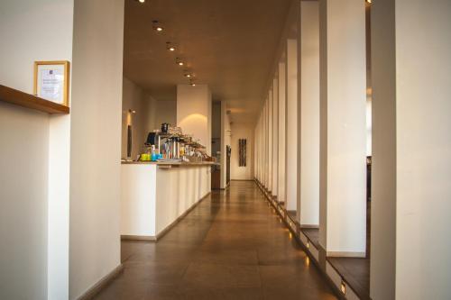 a long hallway with white columns in a building at Hotel Alexander in Wiesbaden