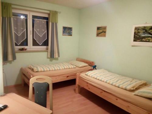 a room with three beds and a window at Pension "Am Tor zum Mainbogen" in Grettstadt