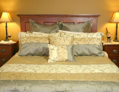 Schlafzimmer mit einem Bett mit einem Kopfteil aus Holz und Kissen in der Unterkunft The Red Coat in Niagara on the Lake