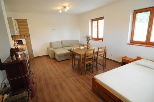 a bedroom with a bed and a table and a couch at Chata Wostry in Bílá