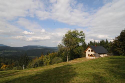 a small house on top of a grassy hill at Chata Wostry in Bílá
